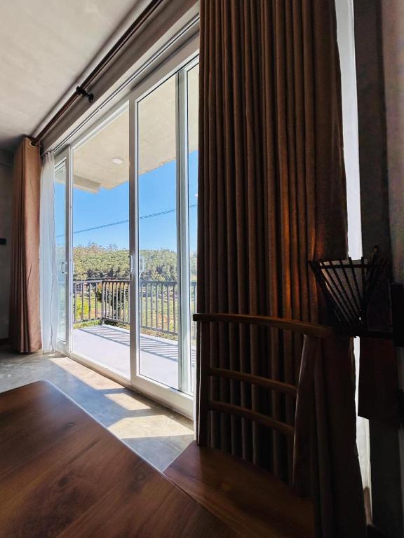 a room with a large window with a view at Viora Lodge in Nuwara Eliya