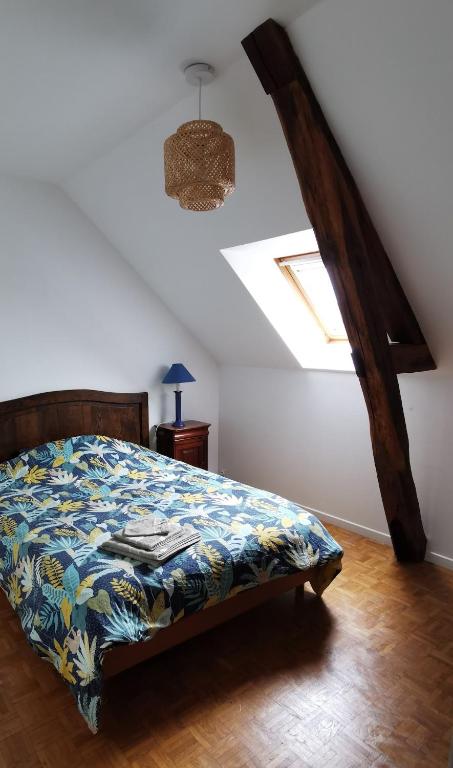 a bedroom with a bed in a room with a ceiling at Maisonnette au calme in Sully-sur-Loire