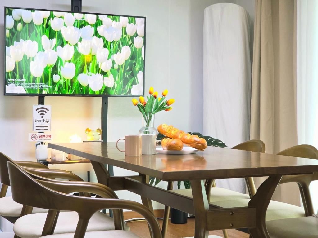 a dining room with a table with chairs and a tv at Wizday Stay in Suwon