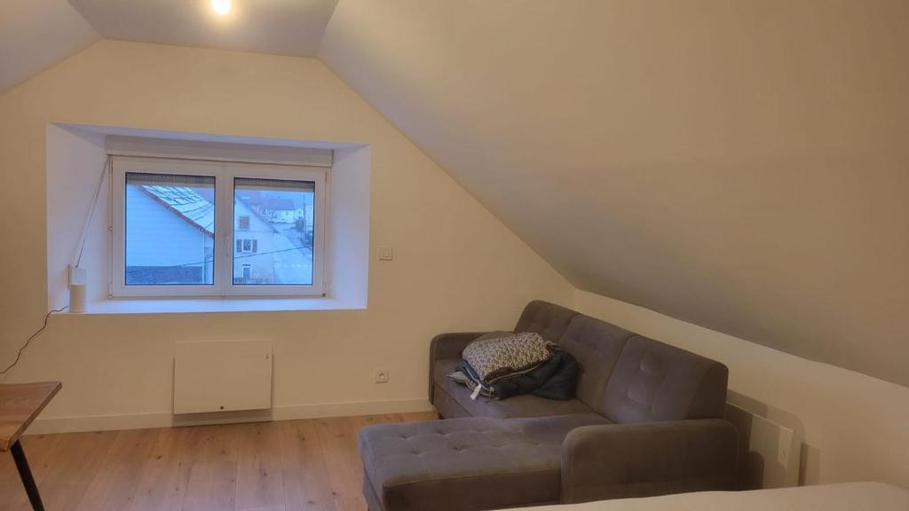 a living room with a couch and a window at Les sapins 201 in Charquemont