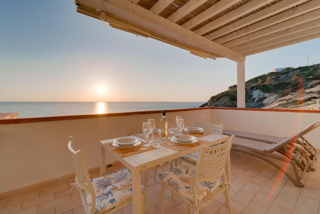 a table and chairs on a balcony with the ocean at Appartamenti - Villa Mare in Pomonte