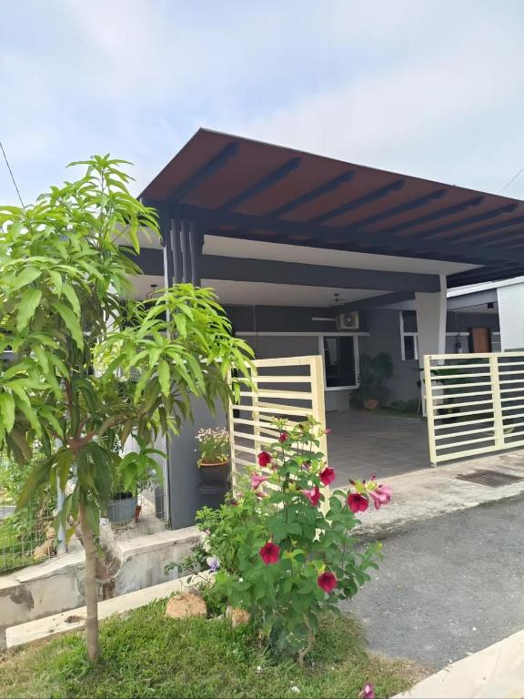 a house with awning and flowers in front of it at Dirindu homestay in Temerloh