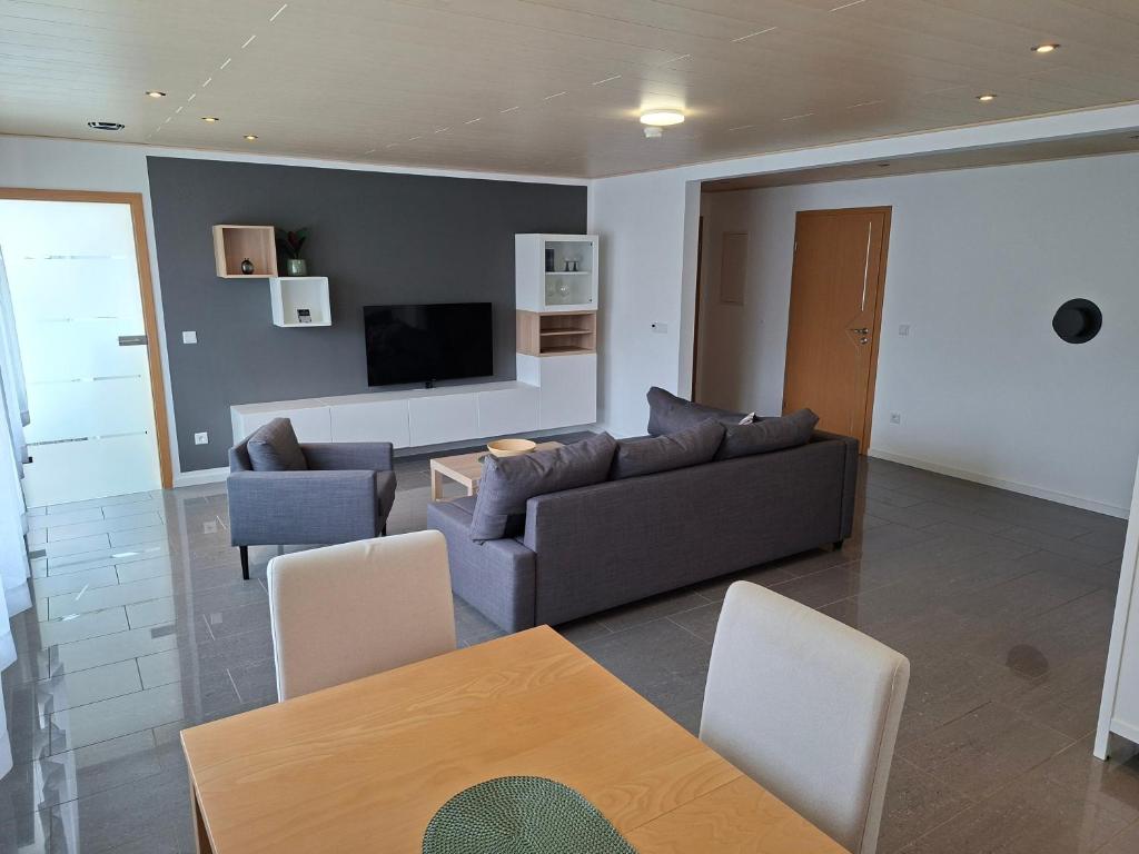 a living room with a couch and a tv at Ferienwohnung Am Anger in Unterleinach
