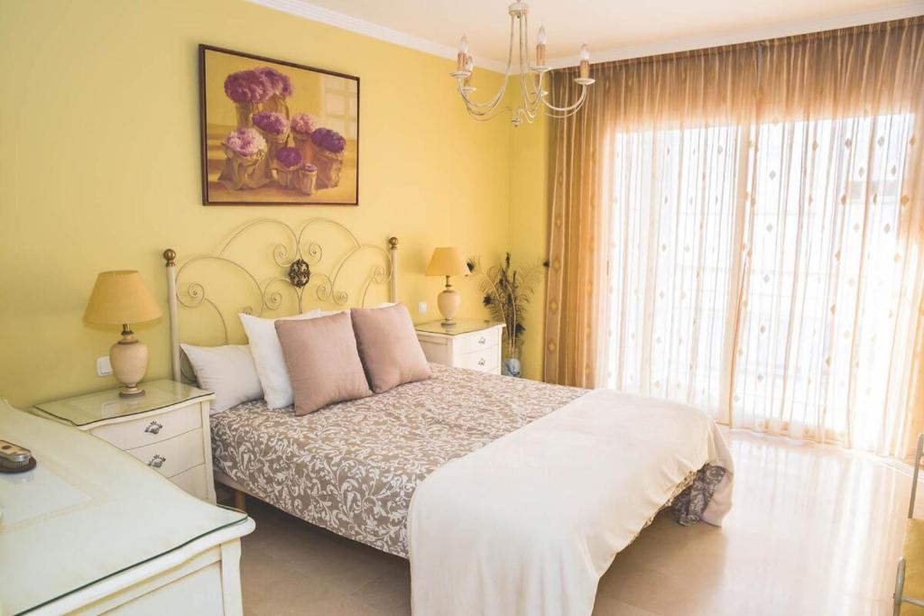 a bedroom with a bed and a chandelier at Spectacular beachfront apartment in Estepona