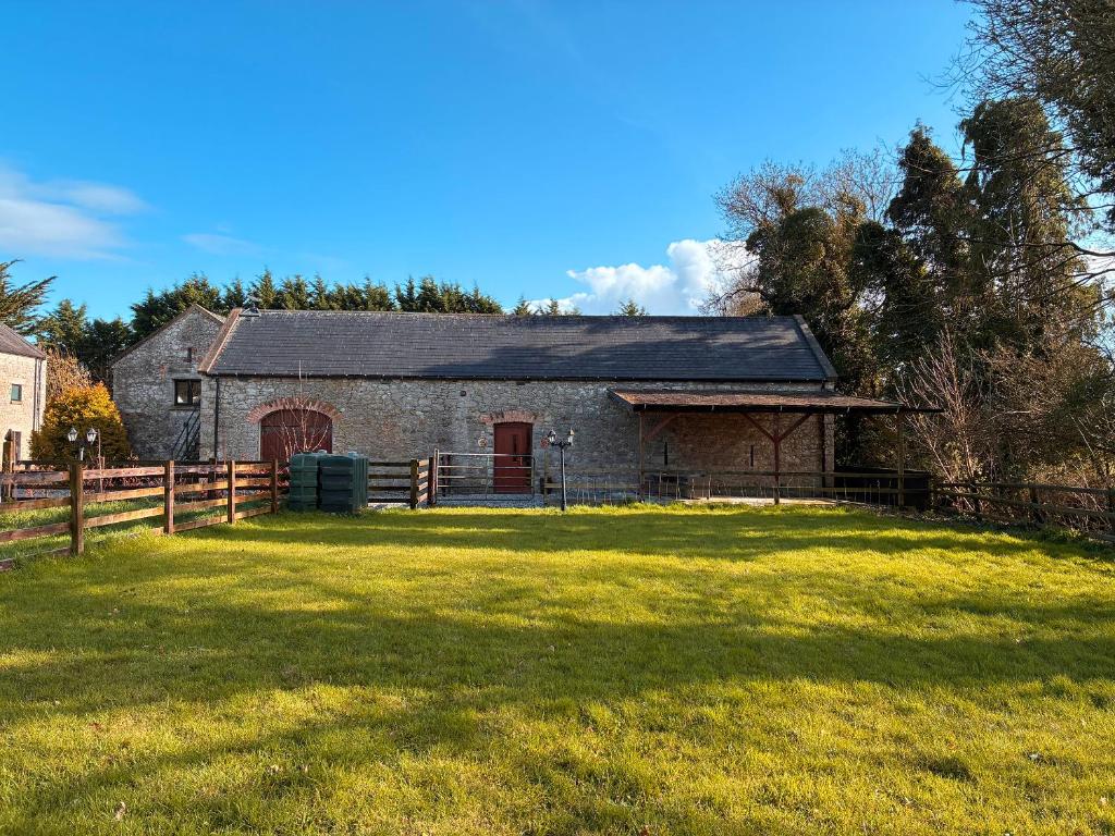 an old stone barn with a grass yard at Woodville Barn in Ród