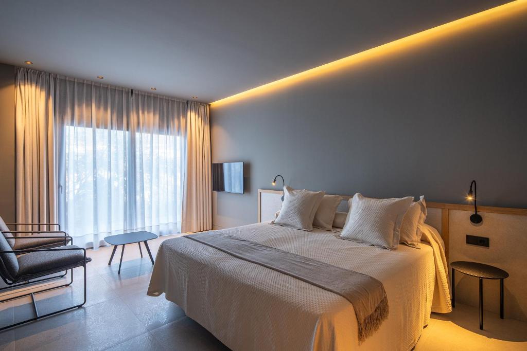 a bedroom with a bed and a chair and a window at The Alma Suite in Alora