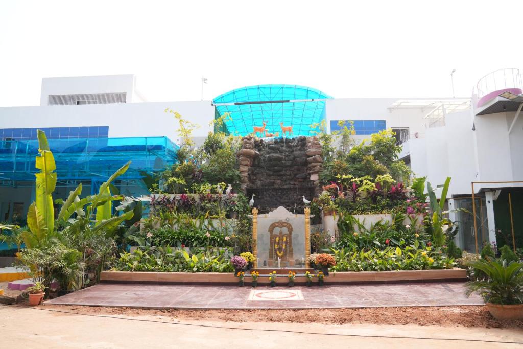 a garden in front of a building with a fountain at Ascent Eco Resorts & Conventions in Rājānagaram