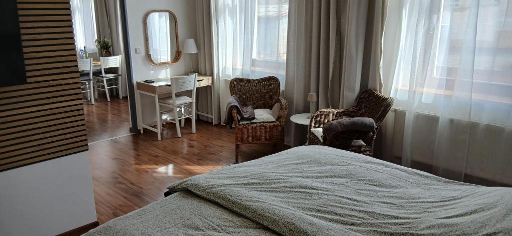 a bedroom with a bed and a desk and chairs at Apartmány Šrámek Stříbro in Stříbro
