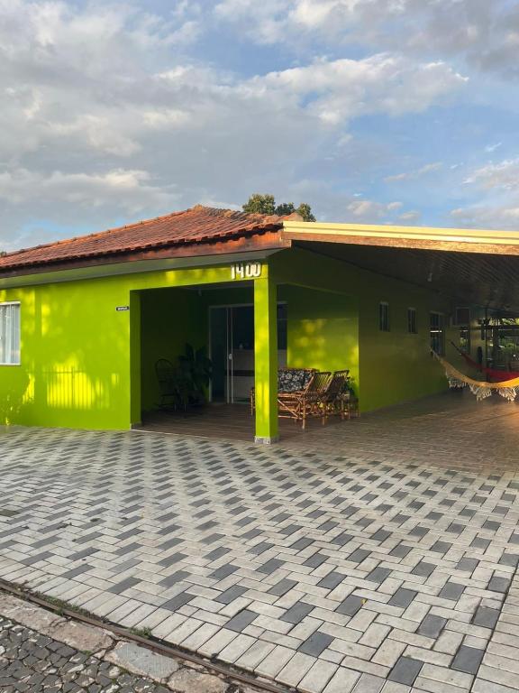 a yellow building with a patio in front of it at Pousada Avenida in Tibagi