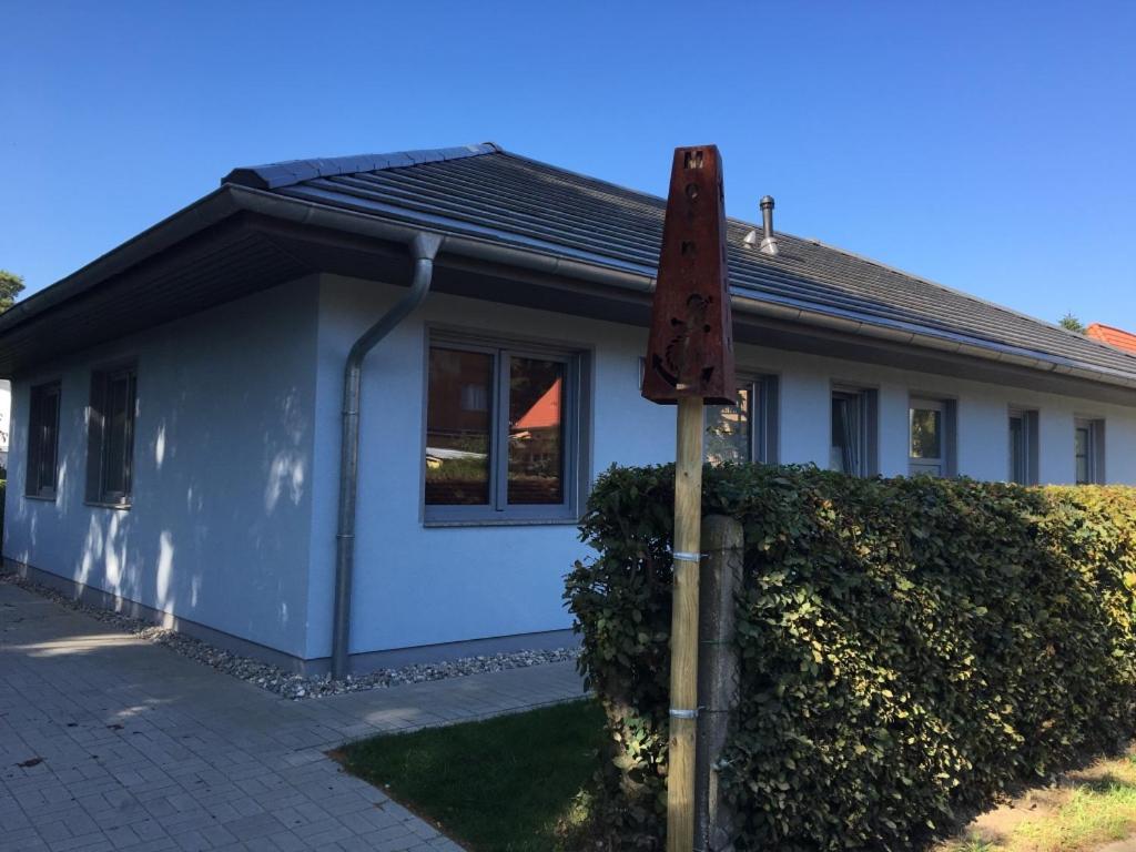 a blue house with a sign in front of it at Ferienwohnung ANKER in Lubmin
