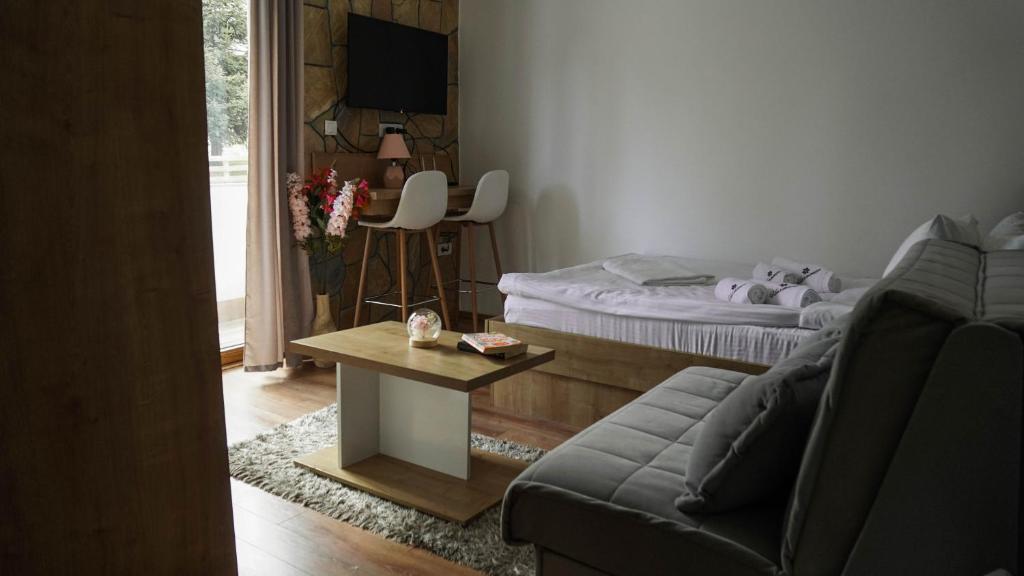 a living room with a bed and a couch and a table at Hop Kop in Kopaonik