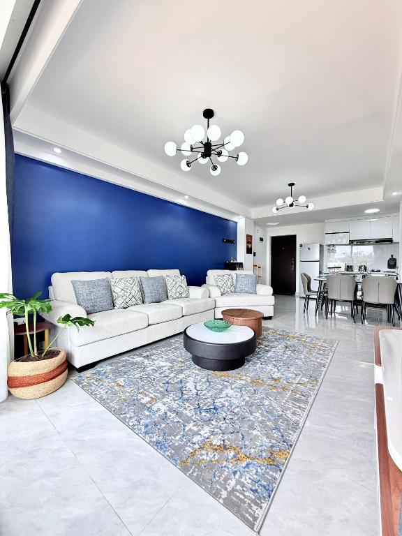 a living room with a white couch and a blue wall at Araka Homes-Westlands in Nairobi
