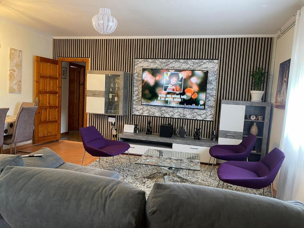 a living room with a couch and purple chairs at Large and cozy studio in Piera