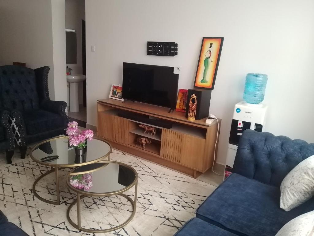 a living room with a tv and a couch and a table at Peaceful Paradise in Gatunga
