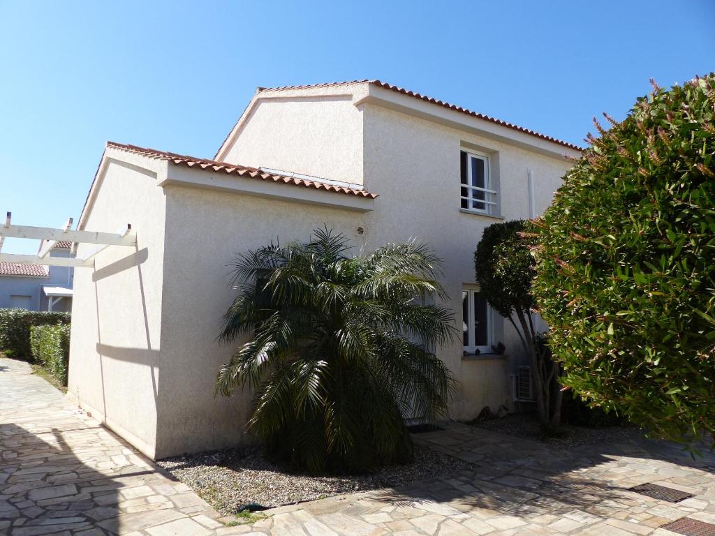 a white house with a palm tree in front of it at villa Montecristo in Cervione