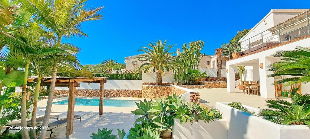 a villa with a swimming pool and palm trees at Villa Erika by Solidays in Moraira