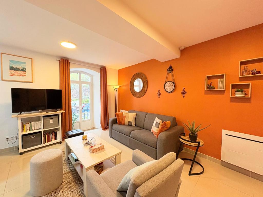 a living room with a couch and a tv at L'Ariane, Vue sur le château in Foix
