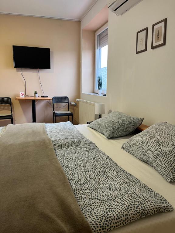 a bedroom with a bed and a tv on the wall at Rooms with private Bathroom & Free Parking ''Sobe Zoka,, in Subotica