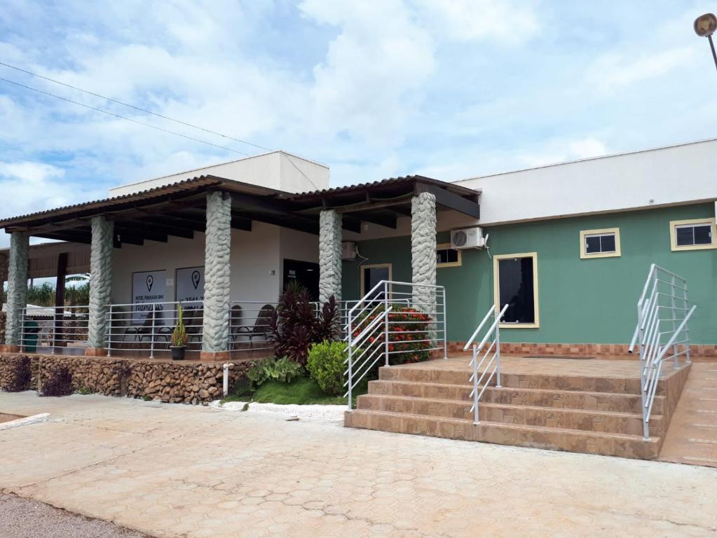 a green house with a staircase in front of it at Hotel Pousada das Palmeiras in Colíder
