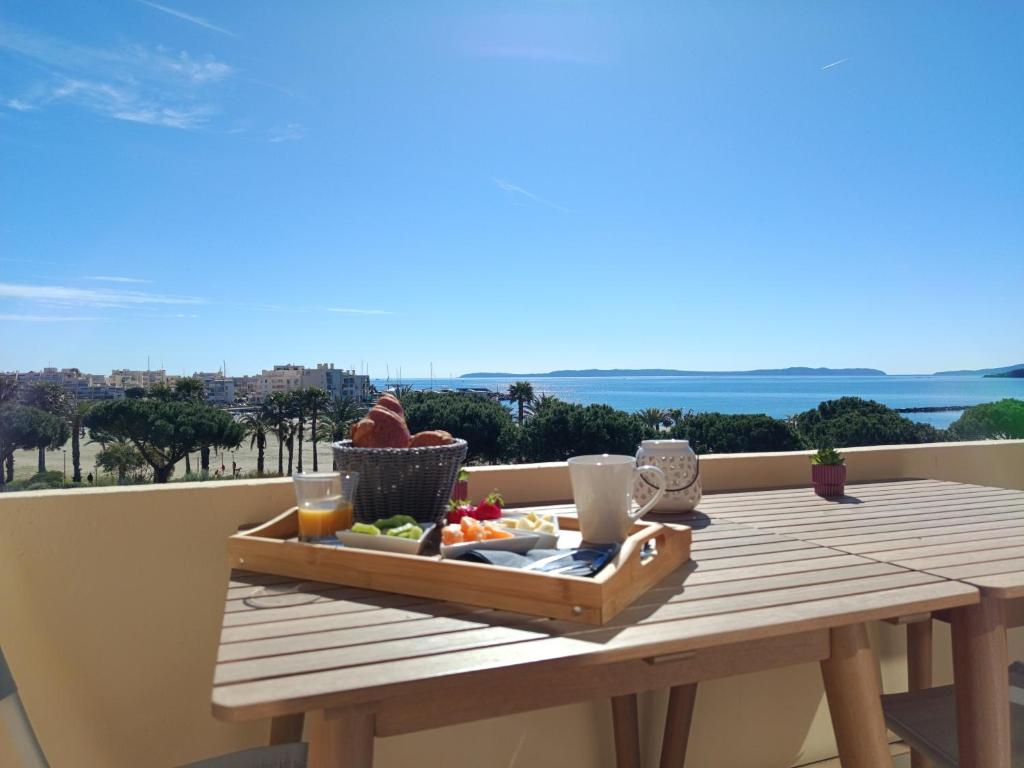 a wooden table with a tray of food on a balcony at L'endroit in Bormes-les-Mimosas