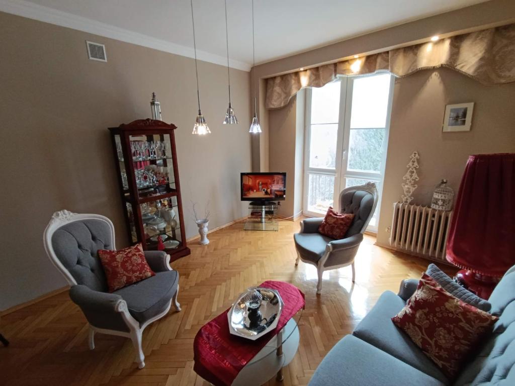 a living room with two chairs and a tv at Apartament 16 in Sandomierz