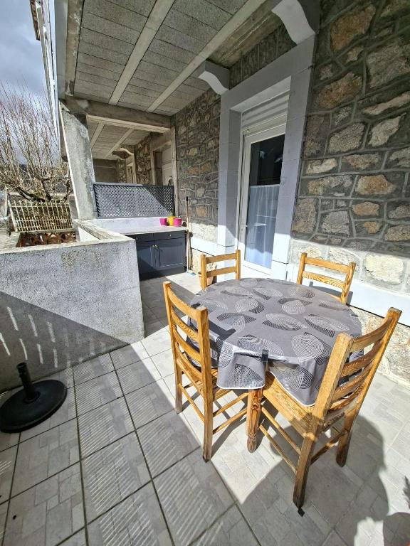 a table and chairs on a patio with a kitchen at Appartement Véronica - Villa Damary in La Bourboule