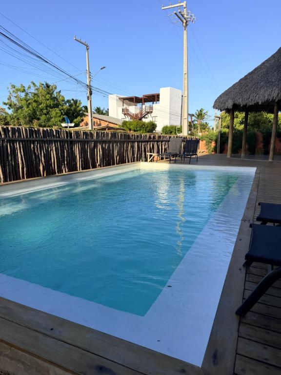a swimming pool next to a wooden fence at BobZ Concept in Barrinha
