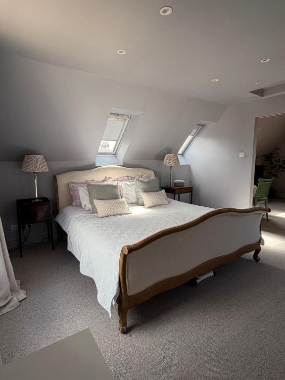 a bedroom with a large bed with two windows at The Bothy in Pewsey