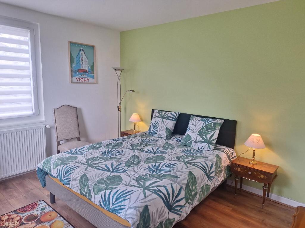 a bedroom with a bed and two lamps and a window at chambre d'hôte in Saint-Rémy-en-Rollat