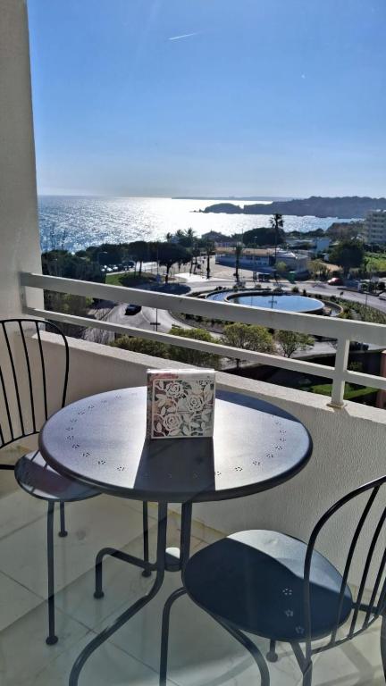 a table and chairs on a balcony with a view of the ocean at Da Rocha Beach 50M, AMAZING Sunset SEA VIEW in Portimão
