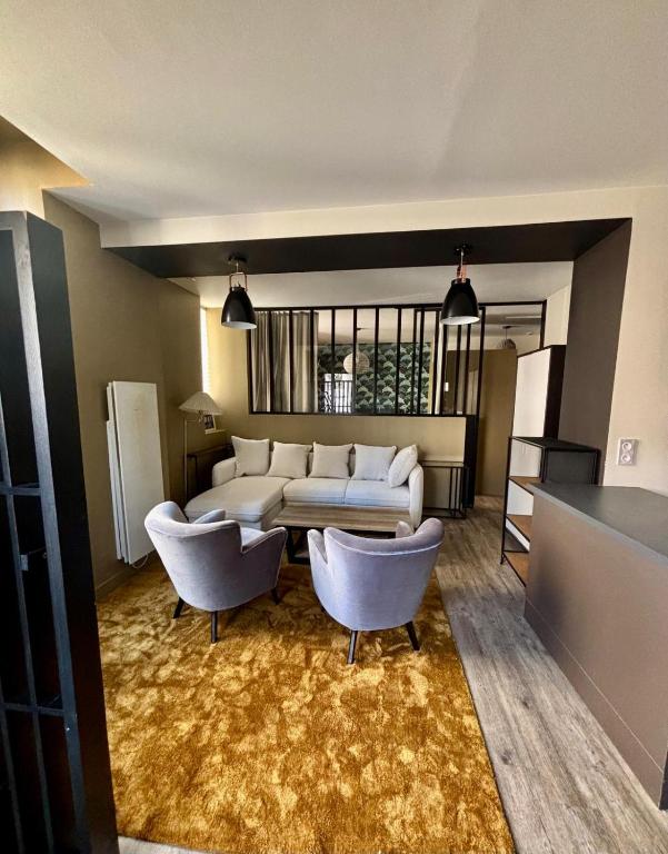 a living room with a couch and two chairs at Au Saint Martin in Cholet
