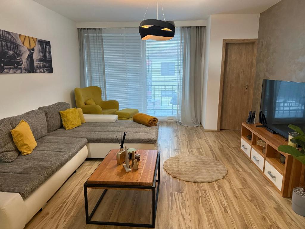 a living room with a couch and a television at Prestige Suite DS in Dunajská Streda