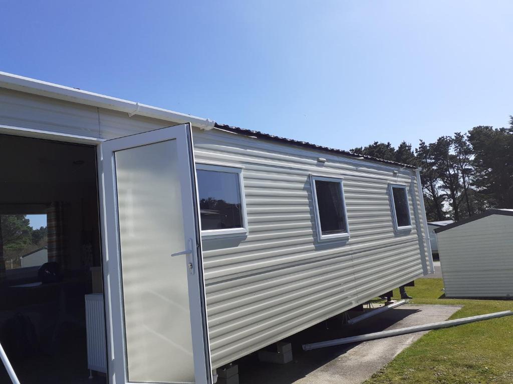 a silver trailer with a door open in a yard at Caravan Holiday Park in Newquay in Newquay