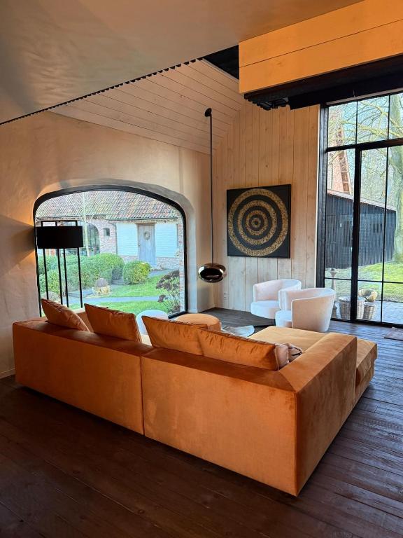 a living room with a couch and a large window at Rust en natuur in de Vlaamse Ardennen in Kluisbergen