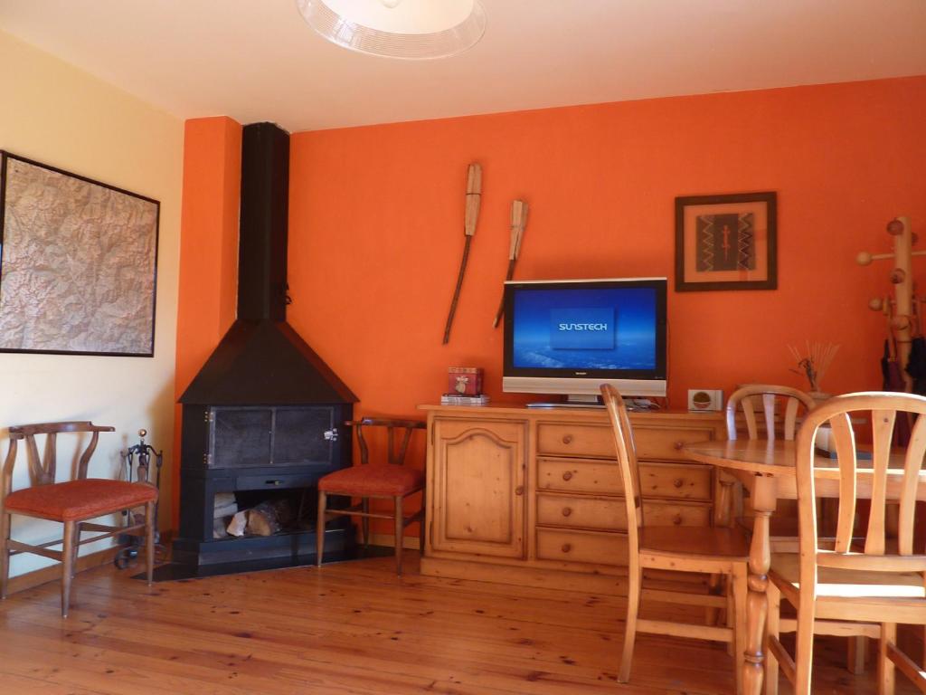 a living room with a tv and a wood stove at Apartamento Plaza Ballo in Bohí