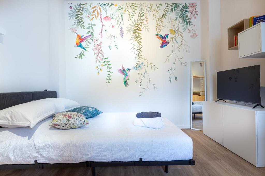 a room with a bed with a television and butterflies on the wall at Colibrì in Milan