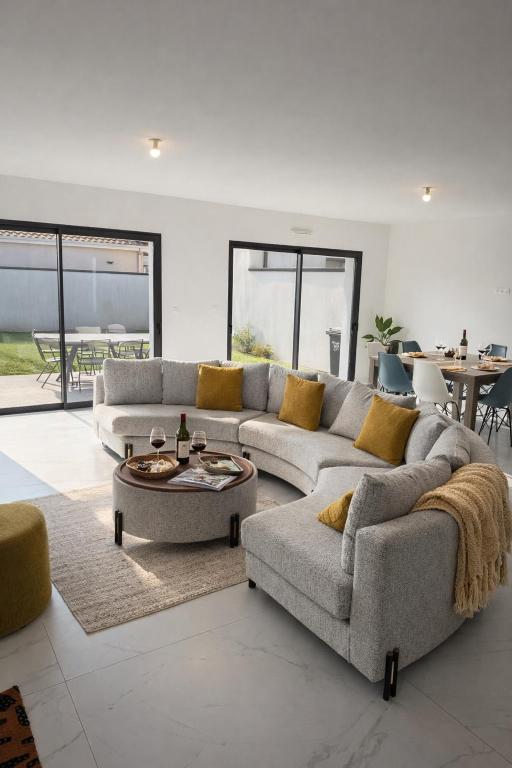 a living room with two couches and a table at Maison moderne in Saint-Julien-de-Concelles
