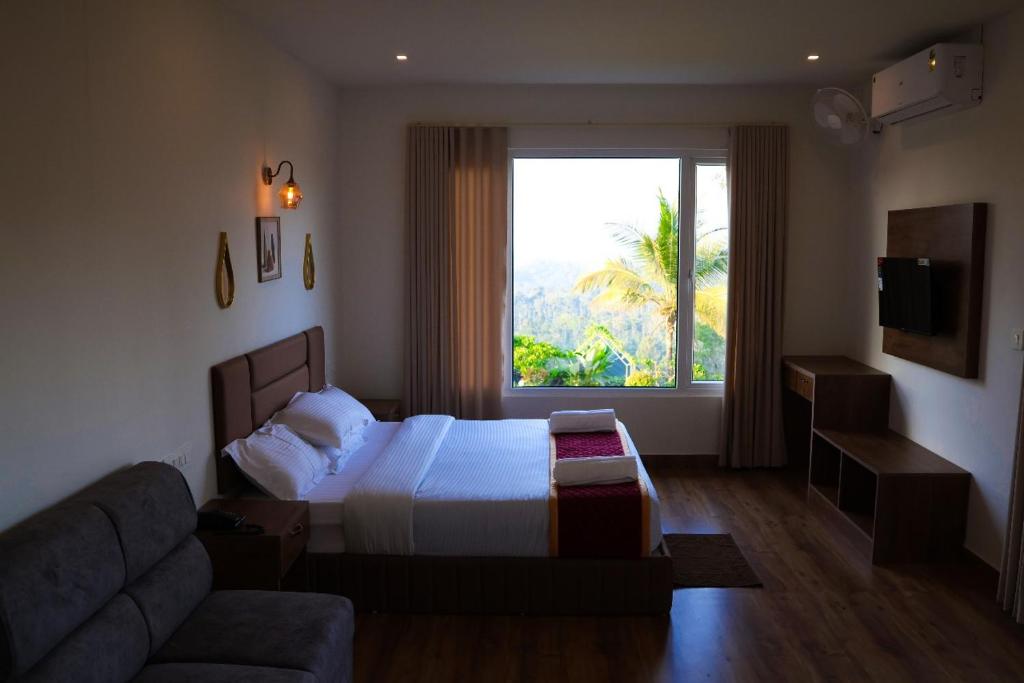 a bedroom with a bed and a couch and a window at Misty Bean Resort in Meppādi