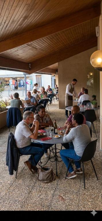 a group of people sitting at a table eating at Hotel - Restaurant de la Paix in Barbotan-les-Thermes