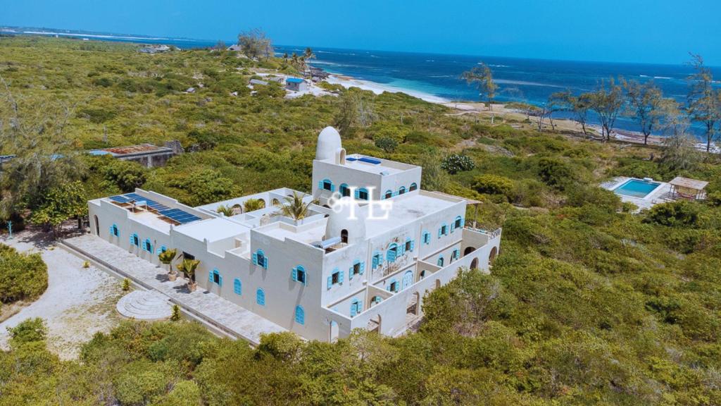 an aerial view of a white house on the beach at Kavunjeni Villa in Uyombo