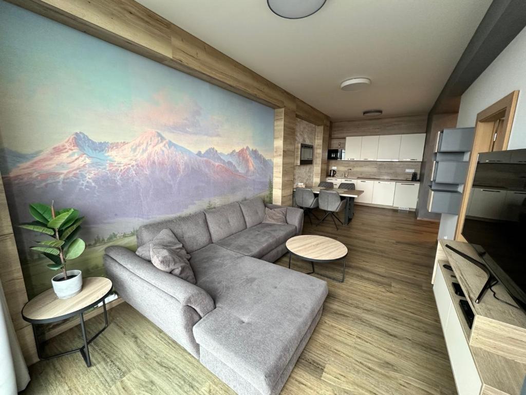 a living room with a couch and a mountain mural at Apartmán Tatrya in Vysoké Tatry