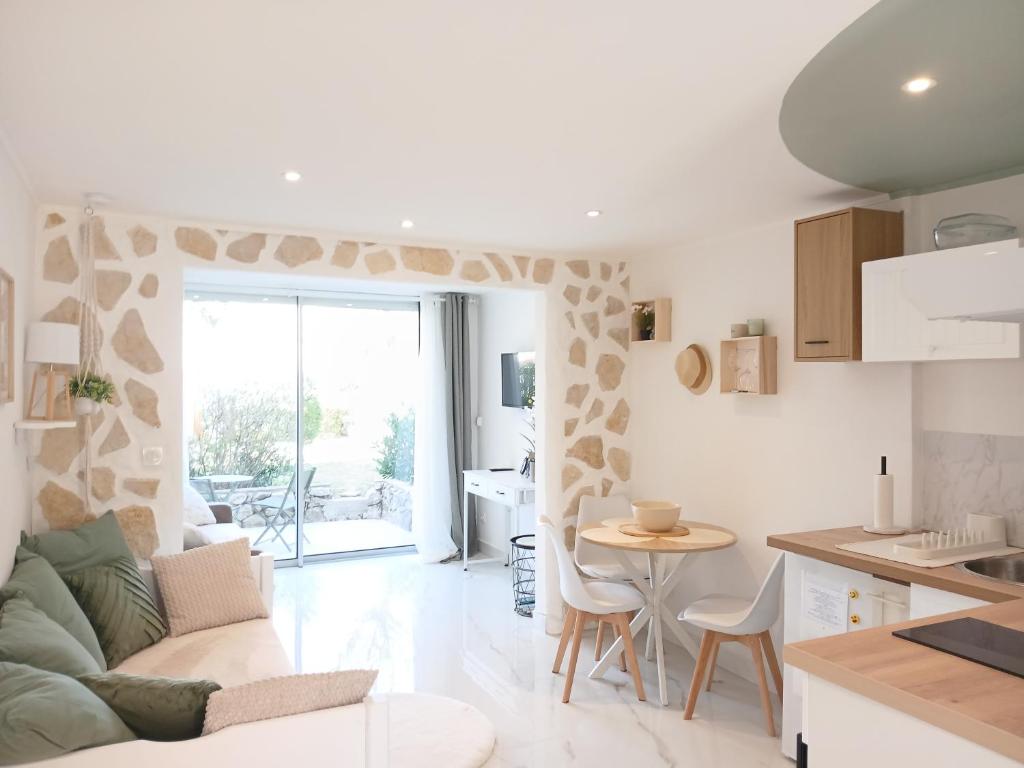a kitchen and living room with a couch and a table at Studio calme avec terrasse et piscine in Saint-Vallier-de-Thiey