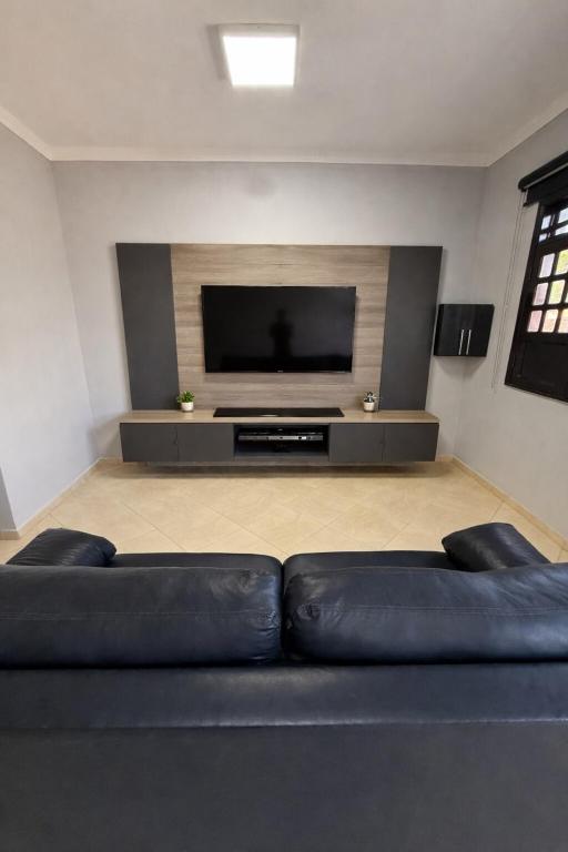 a living room with a black couch and a flat screen tv at Casa Bragança in Bragança
