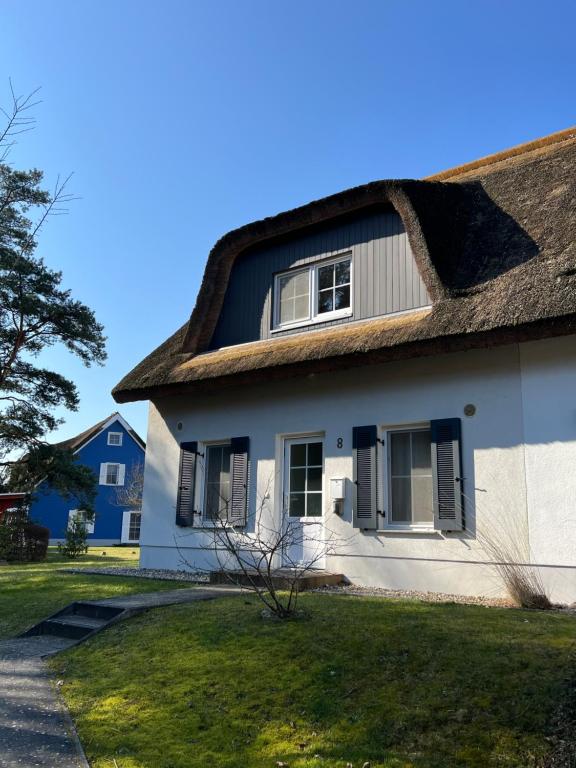 a white house with a thatched roof at Wellenläufer Breege in Breege