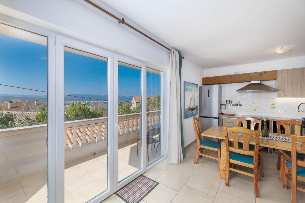 a kitchen and dining room with a view of a balcony at Maleluni in Malinska