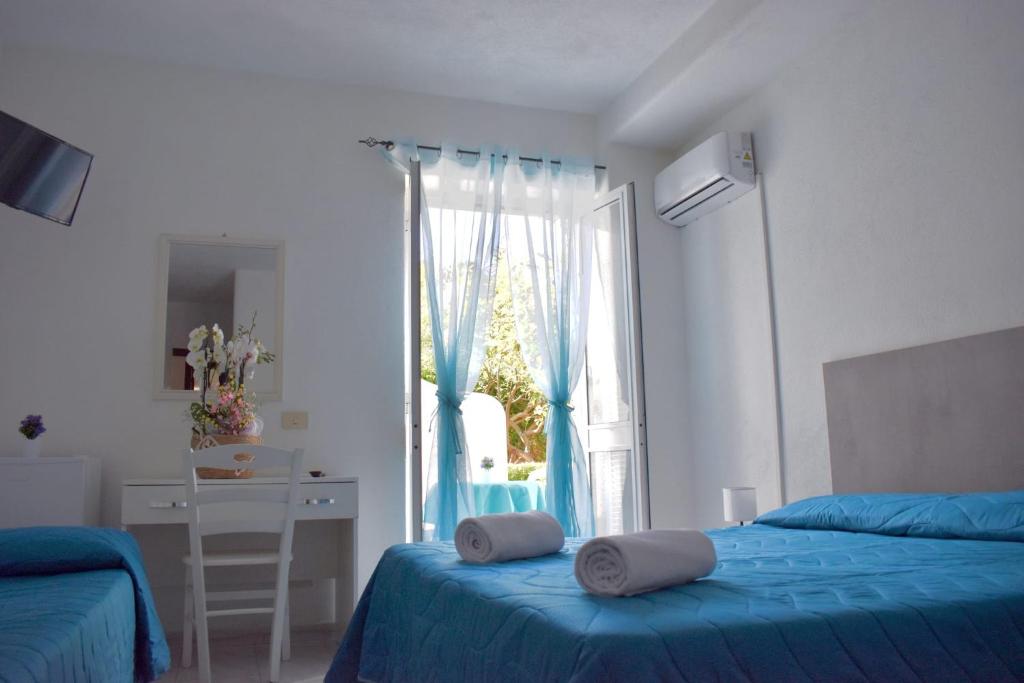 a bedroom with two beds and a large window at Hotel Casa Cigliano in Forio d'Ischia