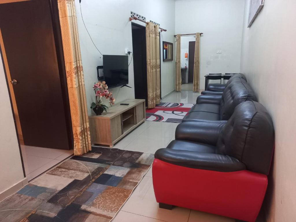 a waiting room with a leather couch and a television at Homestay DC 1 - wifi, netflix in Shah Alam