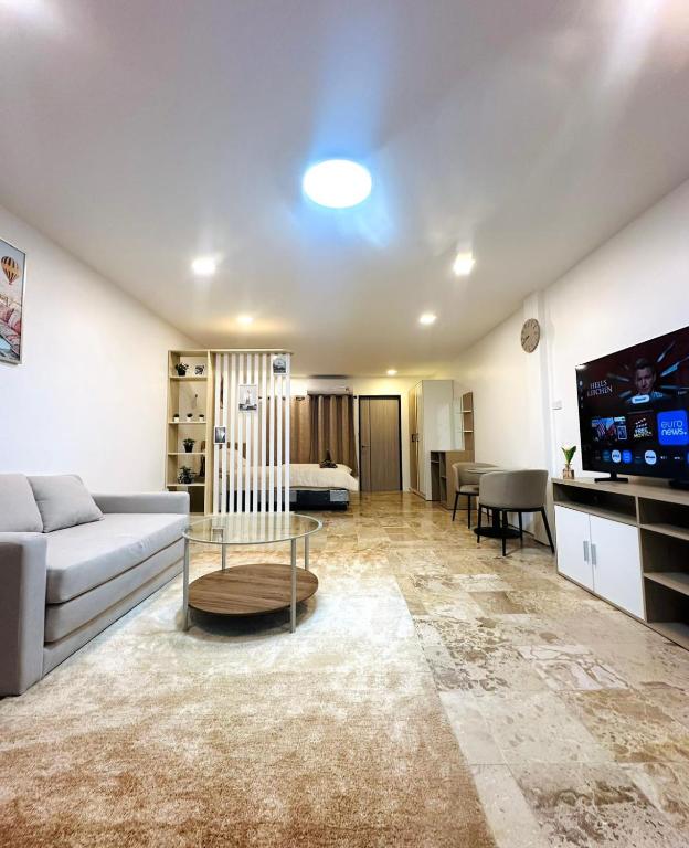 a living room with a couch and a tv at Brand new furnished studio Apartment near old Town in Phuket