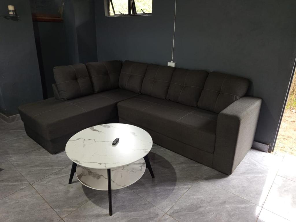 a living room with a couch and a table at Stush In the Bush in Stegi
