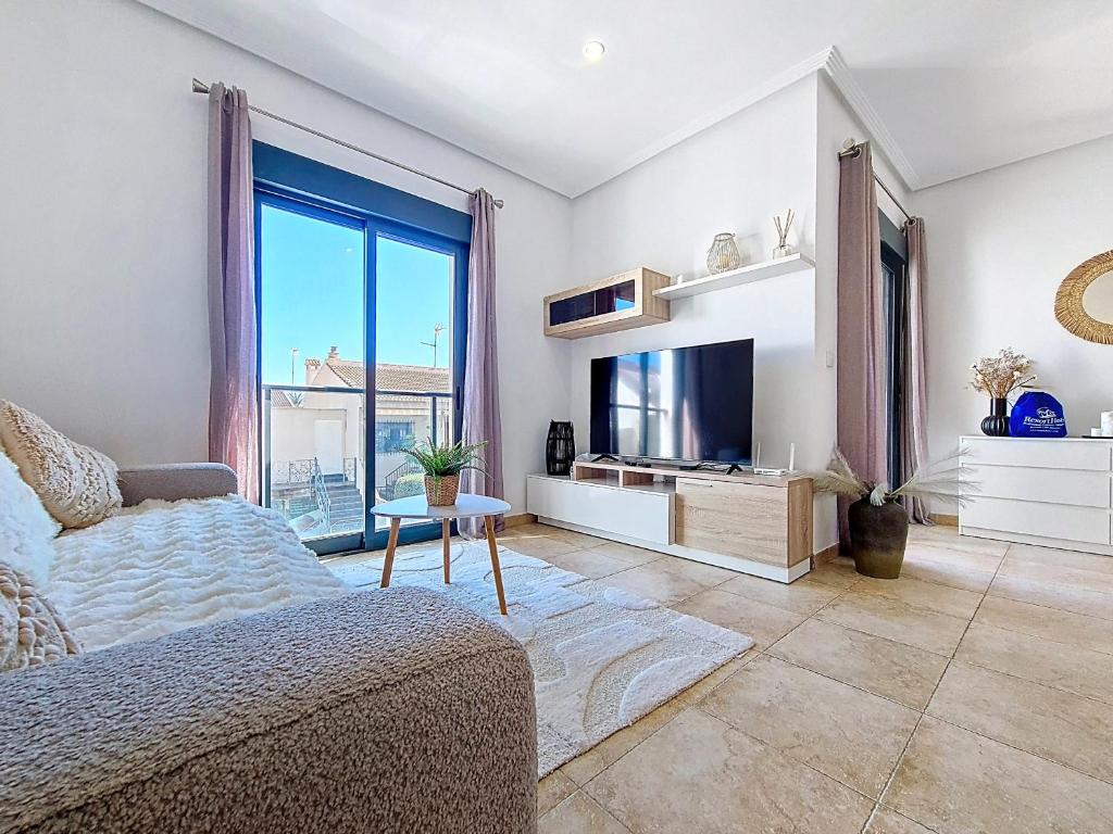a living room with a bed and a television at San Pedro Centro - 9110 in San Pedro del Pinatar